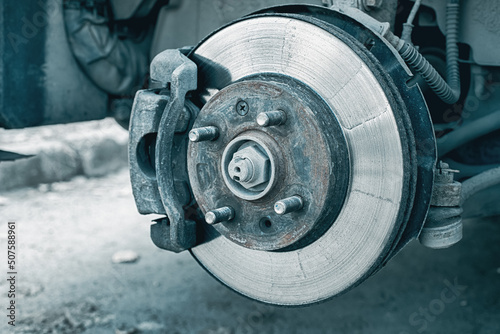 A rusty and old brake disc is serviced or replaced when the car is inspected by a mechanic. Safety and wear of the brake system