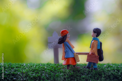 miniature doll couple boy and girl with bag looking at each other with love at the park © Bonn