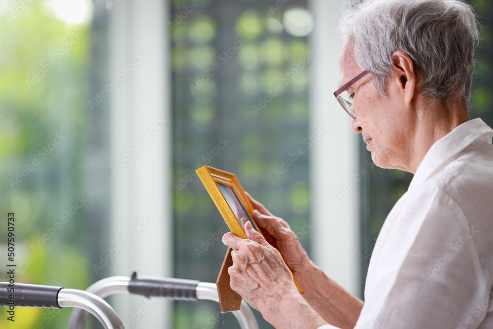 Φωτογραφία Sad old elderly with depression looks at photograph of her family with nostalgia