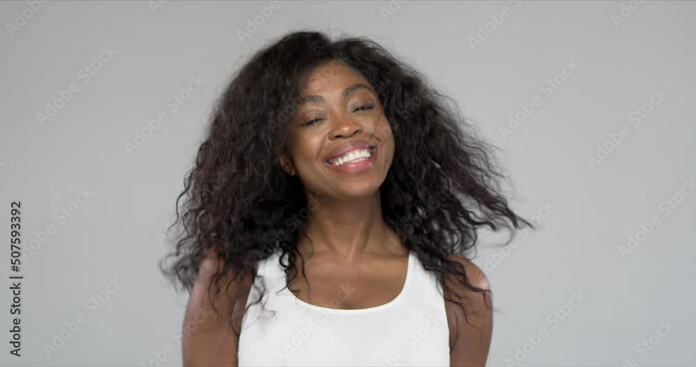 Studio portrait of black woman shaked head and her curly hair