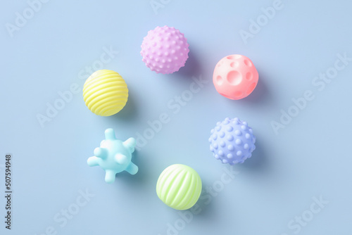 Flat lay rubber kid toys balls for bath on blue background. Minimal style.