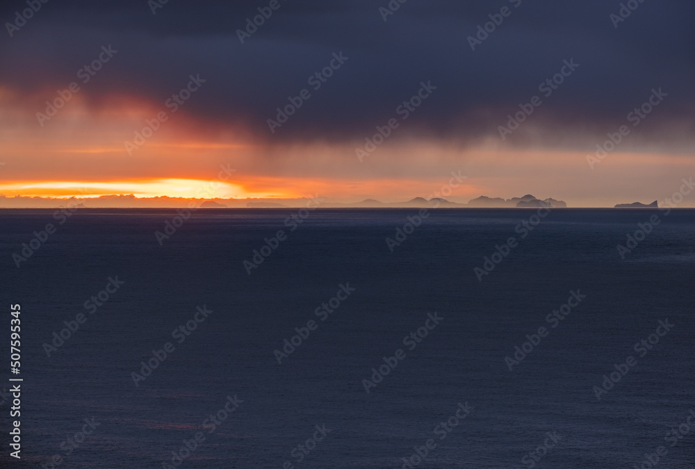 Fototapeta premium Picturesque autumn evening view above Atlantic ocean from Dyrholaey Cape, Vik, South Iceland. Vestmannaeyjar islands weird silhouettes on horizont.