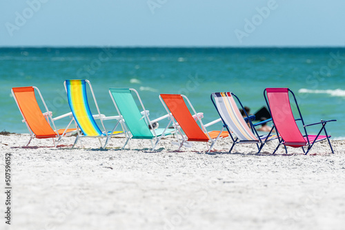 Beach chairs lined up on sand