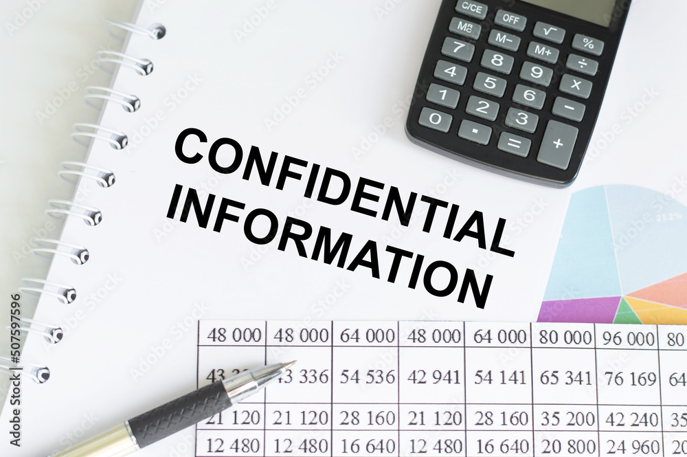 business concept. Notebook with text confidential information on table next to calculator, pen and reports business concept. Notebook with text confidential information on table next to calculator, pen and reports