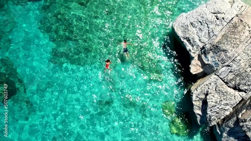 Golfo di Orosei Sardina, View from above, stunning aerial view of a beach full of beach umbrellas and people sunbathing and swimming on turquoise water. Cala Gonone, Sardinia, Italy, Cala Mariolu. photo