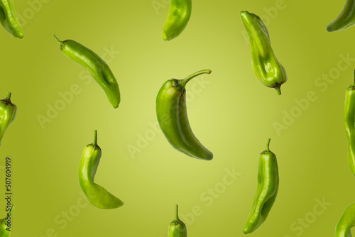 Creative image of green peppers flying on green background. Photo of fresh peppers with copy space.
