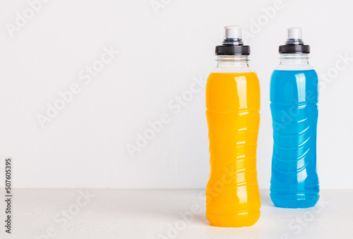 Isotonic energy drink copy space white background. Bottles with blue and yellow water sport beverage.	 photo