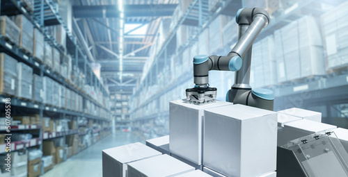 Robot arm moves boxes in an automatic warehouse. Concept