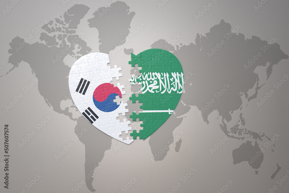 puzzle heart with the national flag of saudi arabia and south korea on a world map background. Concept.