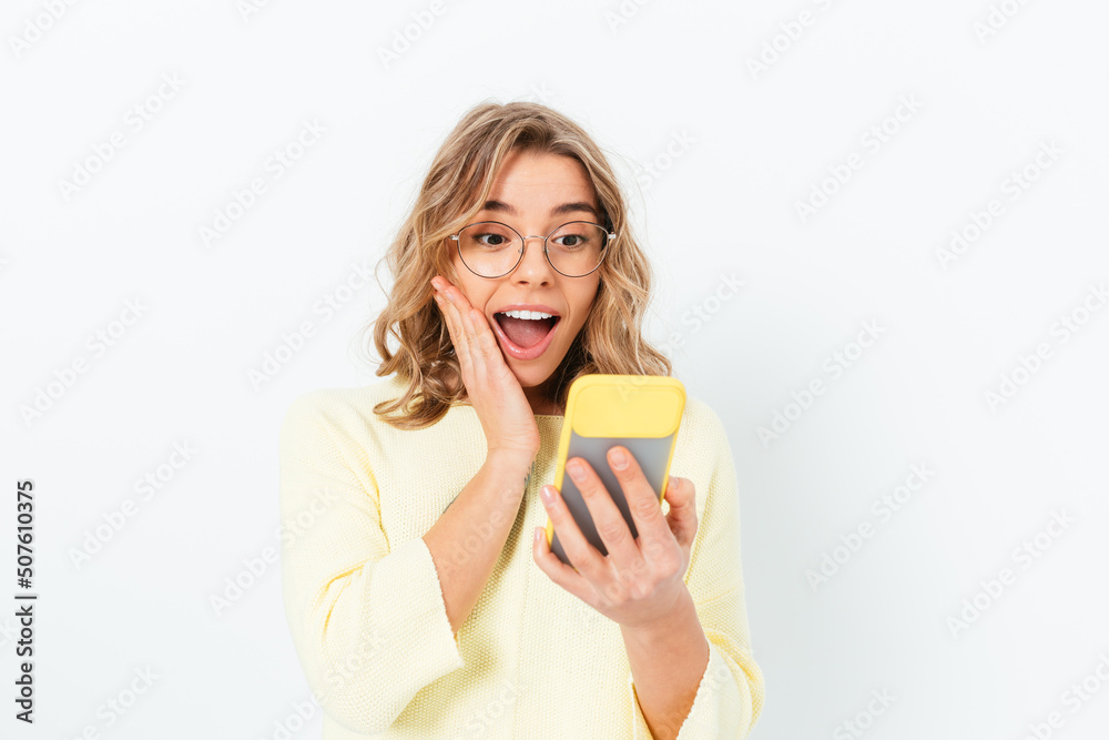 Happy dazed young woman looking into her smartphone Happy dazed young woman looking into her smartphone