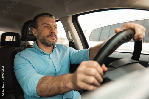 Confident man driving new car in city