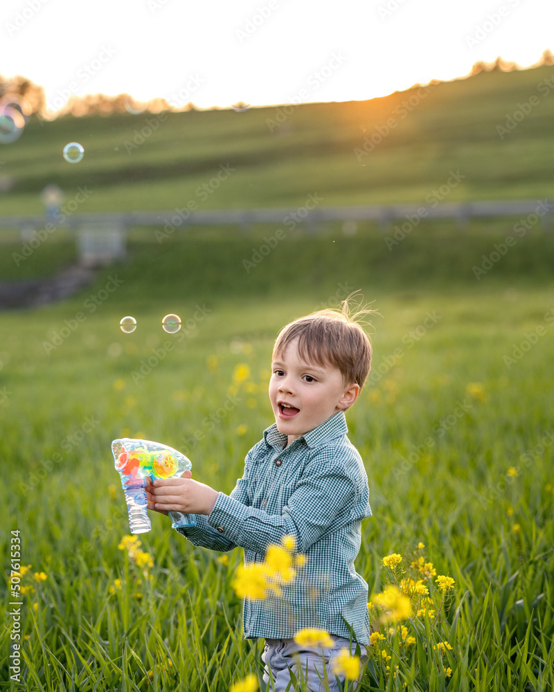 boy playing in a green meadow with yellow flowers