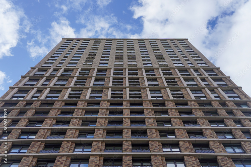 Front up view of modern residential apartement building with blue sky in background Front up view of modern residential apartement building with blue sky in background
