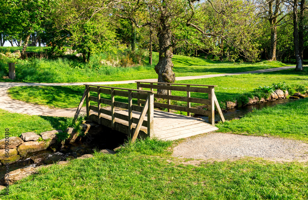 A small wooden bridge across the stream in a small public park near “Sword in Rock” monument, Stavanger, Norway, May 2018 A small wooden bridge across the stream in a small public park near “Sword in Rock” monument, Stavanger, Norway, May 2018