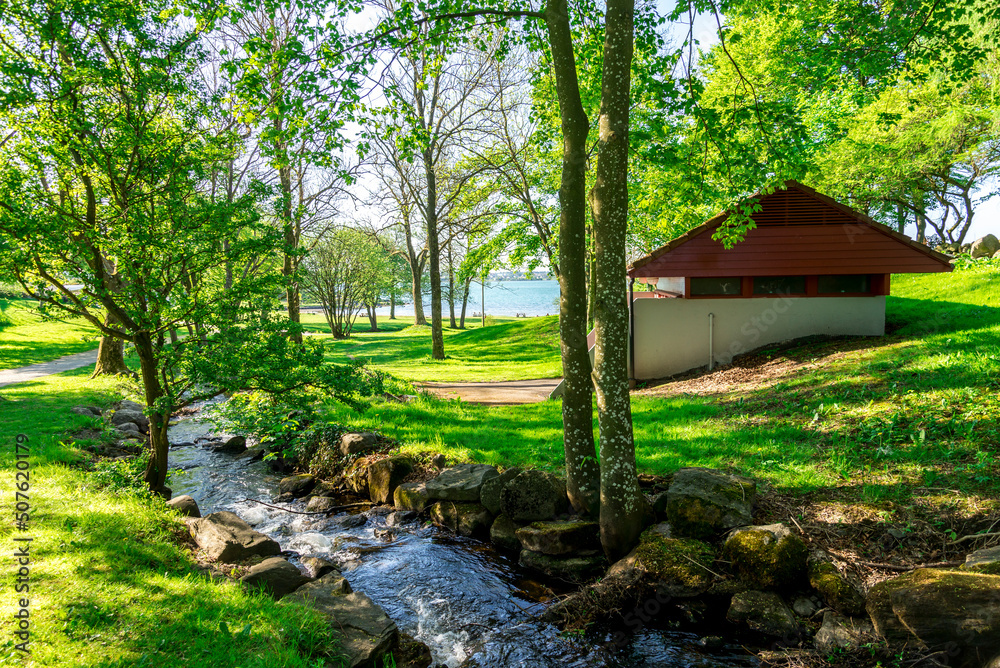 A small park with a water stream running to Hafrsfjord fjord near “Sverd i Fjell” monument, Stavanger, Norway, May 2018