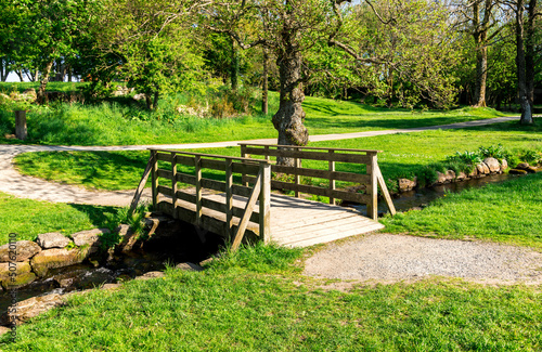 Obraz na płótnie A small wooden bridge across the stream in a small public park near “Sword in Rock” monument, Stavanger, Norway, May 2018 w salonie