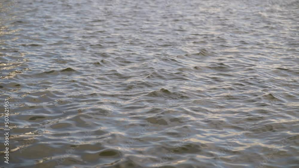 Gentle ripples on a lake water surface from the wind. Wind makes fine ripples in the small waves. Gentle ripples on a lake water surface from the wind. Wind makes fine ripples in the small waves.