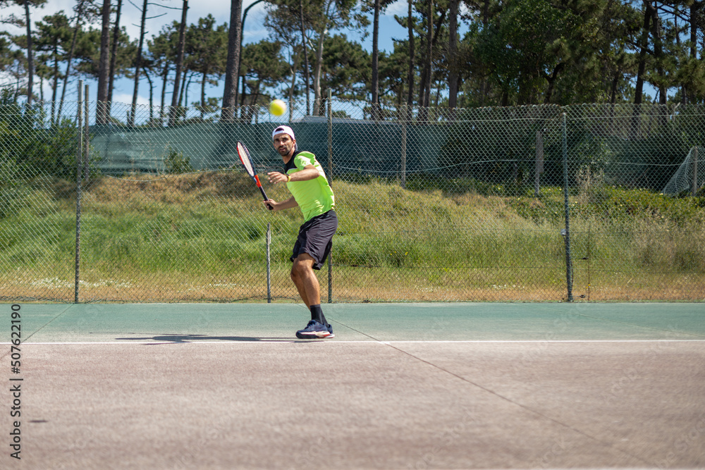 Tennis player hitting forehand at ball