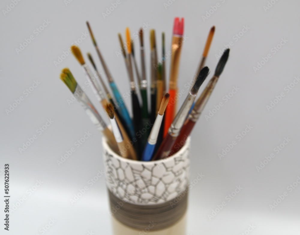 Paint brushes in support. Luxurious glass full of different brushes Paint brushes in support. Luxurious glass full of different brushes