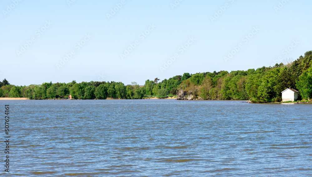 Coastline view of Halandsvatnet lake with green forest trees, Stavanger, Norway, May 2018