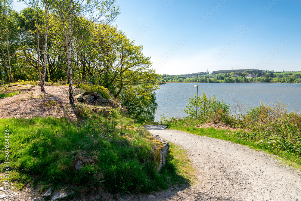 A gravel walking path running downhill to Halandsvatnet lake, Stavanger, Norway, May 2018