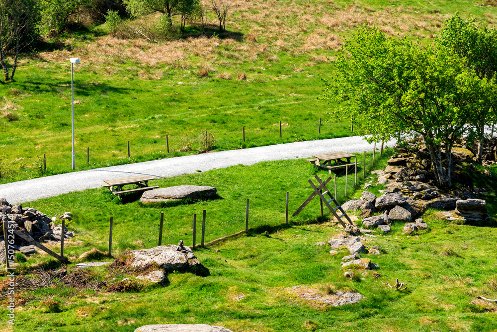 Picnic tables next to a gravel walking path around Halandsvatnet lake, Stavanger, Norway, May 2018