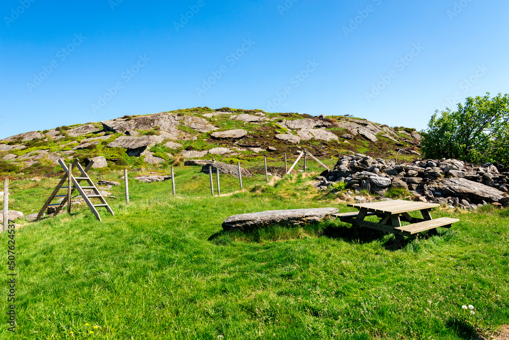 A picnic table and a ladder over the fence to hike the hill for Halandsvatnet lake viewpoint, Stavanger, Norway, May 2018