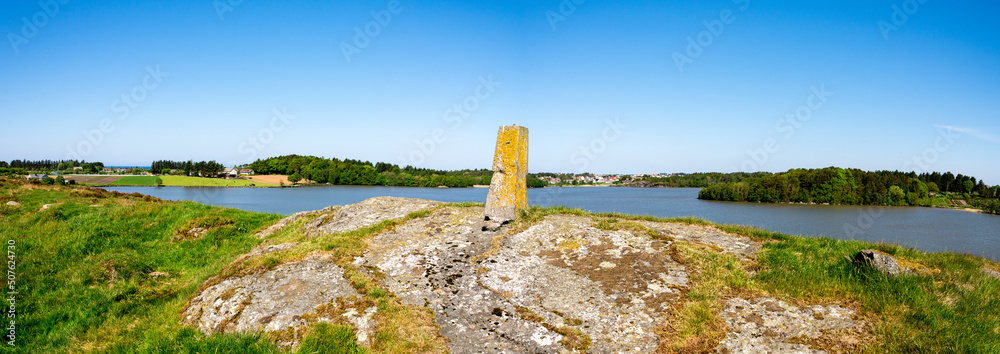 Panoramic view to Halandsvatnet lake from a small hill with an old stone post, Stavanger, Norway, May 2018
