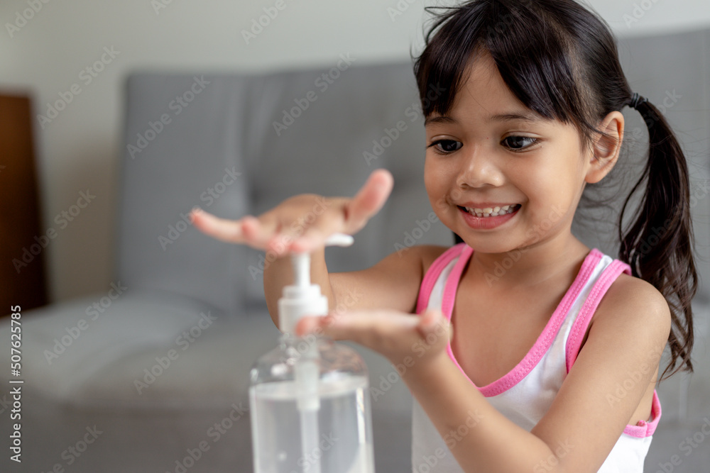 Little Asian girl child put alcohol gel sanitizer pump on Hands for cleaning or wash his hands. Little Asian girl child put alcohol gel sanitizer pump on Hands for cleaning or wash his hands.