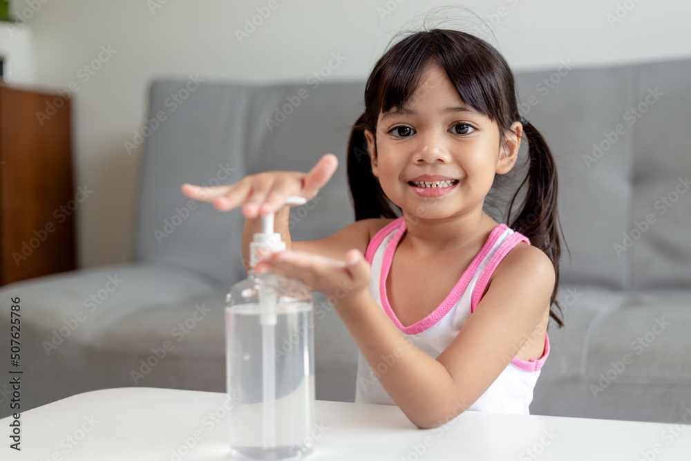 Little Asian girl child put alcohol gel sanitizer pump on Hands for cleaning or wash his hands. Little Asian girl child put alcohol gel sanitizer pump on Hands for cleaning or wash his hands.