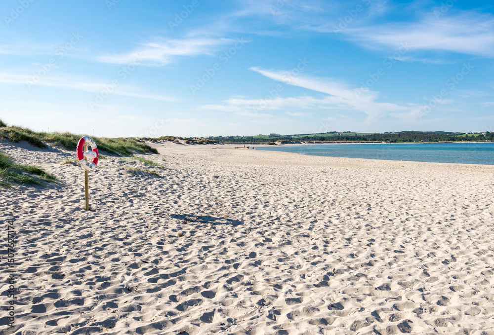 A lifebuoy ring on a wooden post at Sola strand beach in the beginning of summer, Stavanger, Norway, May 2018