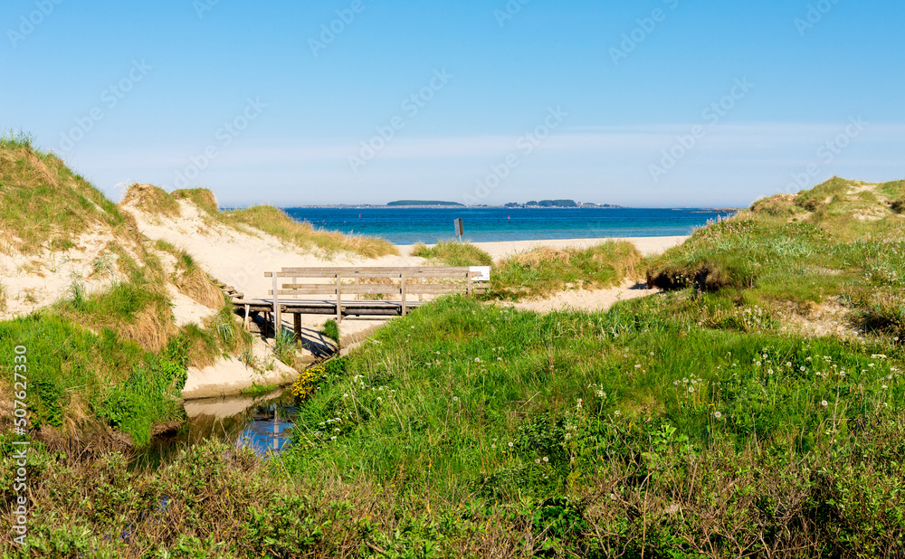 A small wooden bridge over a narrow stream at the entrance to Sola beach, Stavanger, Norway, May 2018