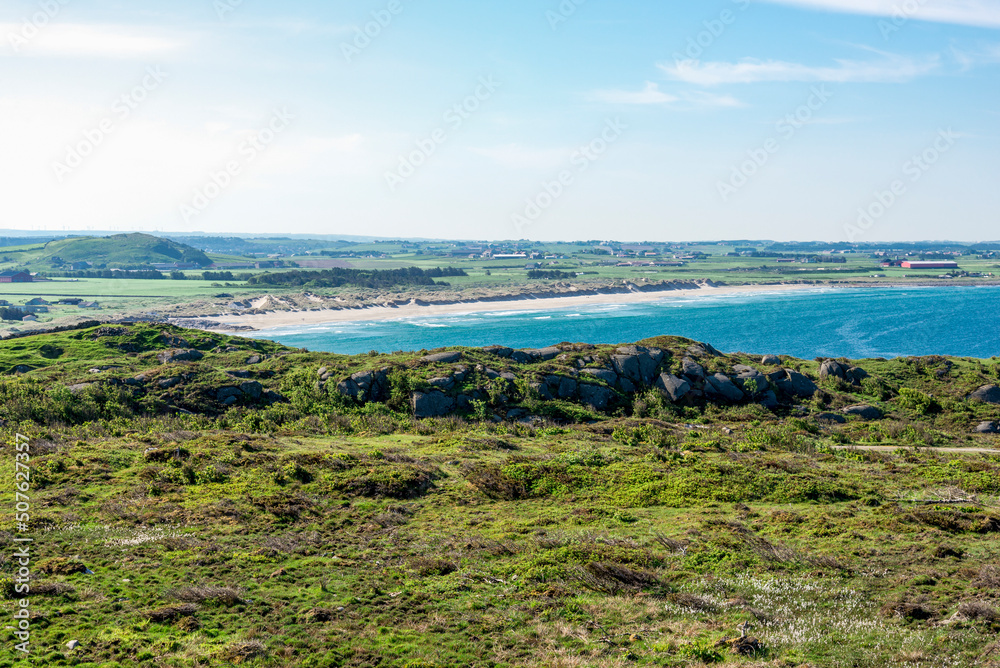 A distant view to beautiful long Hellestostranden white sand beach while hiking along the North sea coast, Stavanger city, Norway, May 2018