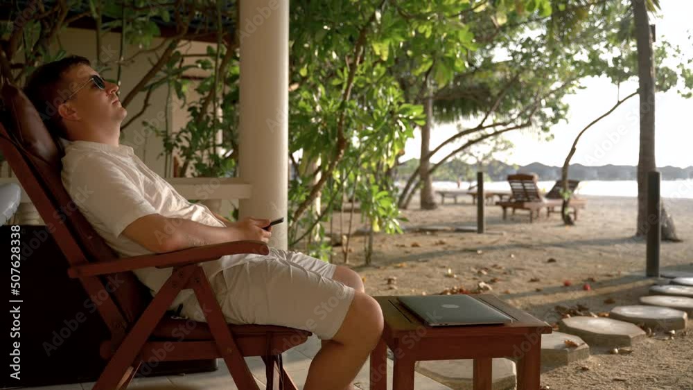 custom made wallpaper toronto digitalA man lies on a chair on the beach waiting for confirmation of successful transactions. The concept of a winning businessman in a tropical paradise