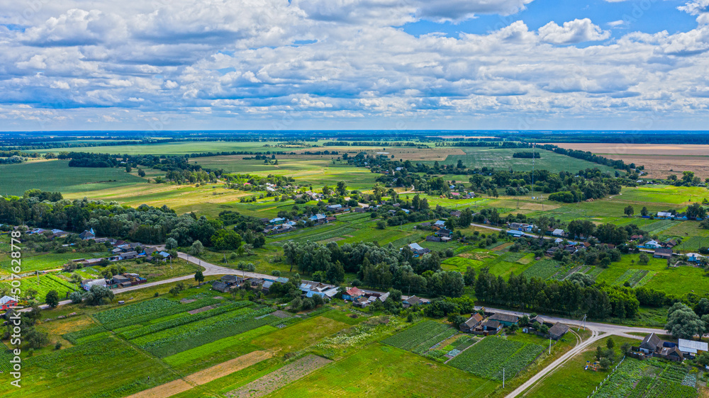 Aerial view over beautiful suburb in  wide valley, in the summer.  Top view to the small village with a beautiful green landscape.