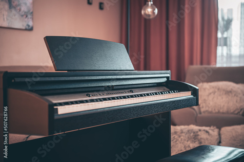 Electronic piano in the interior of the room on a blurred background.