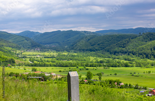 Foto A sign of the tourist route Via Transilvanica and in the background a mountain l