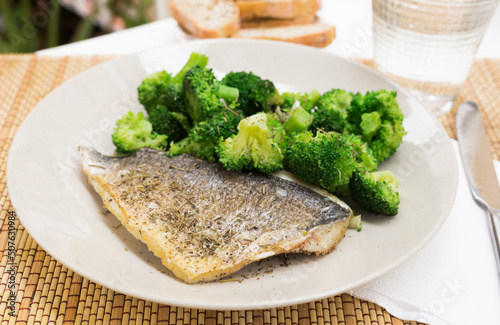 dish of fried dorado fish fillet with boiled broccoli