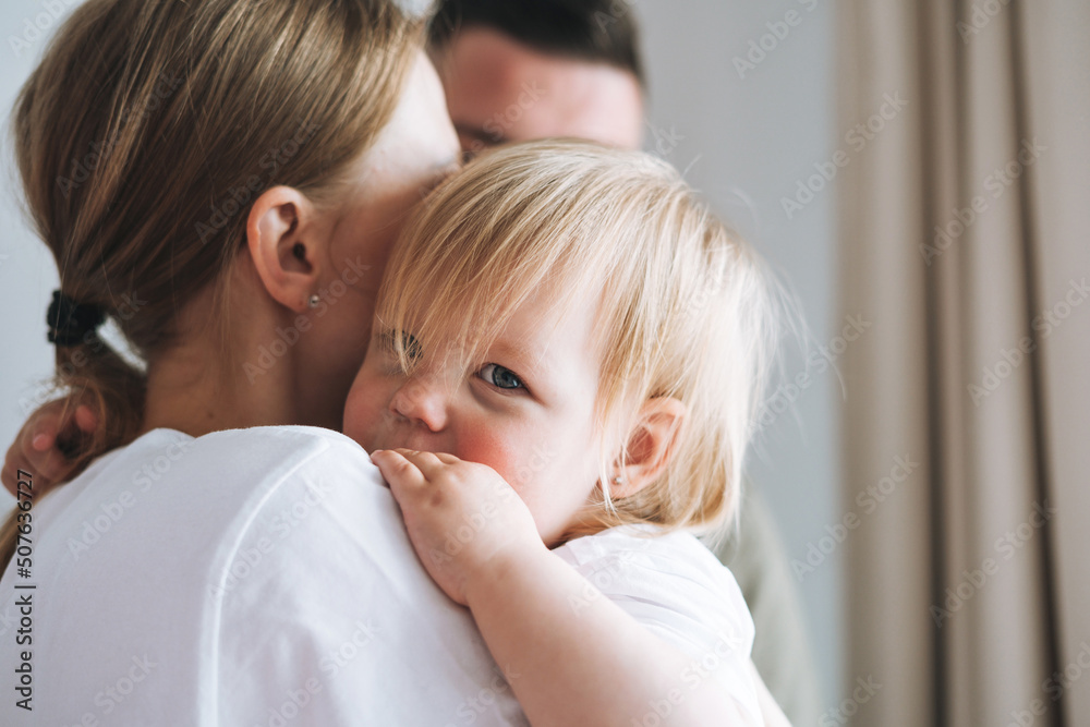 Close up portrait of family father young man and mother with baby girl little daughter near window at home Close up portrait of family father young man and mother with baby girl little daughter near window at home