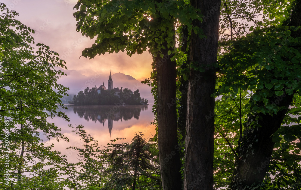 Lake Bled on a misty summer morning on a colorful sunrise