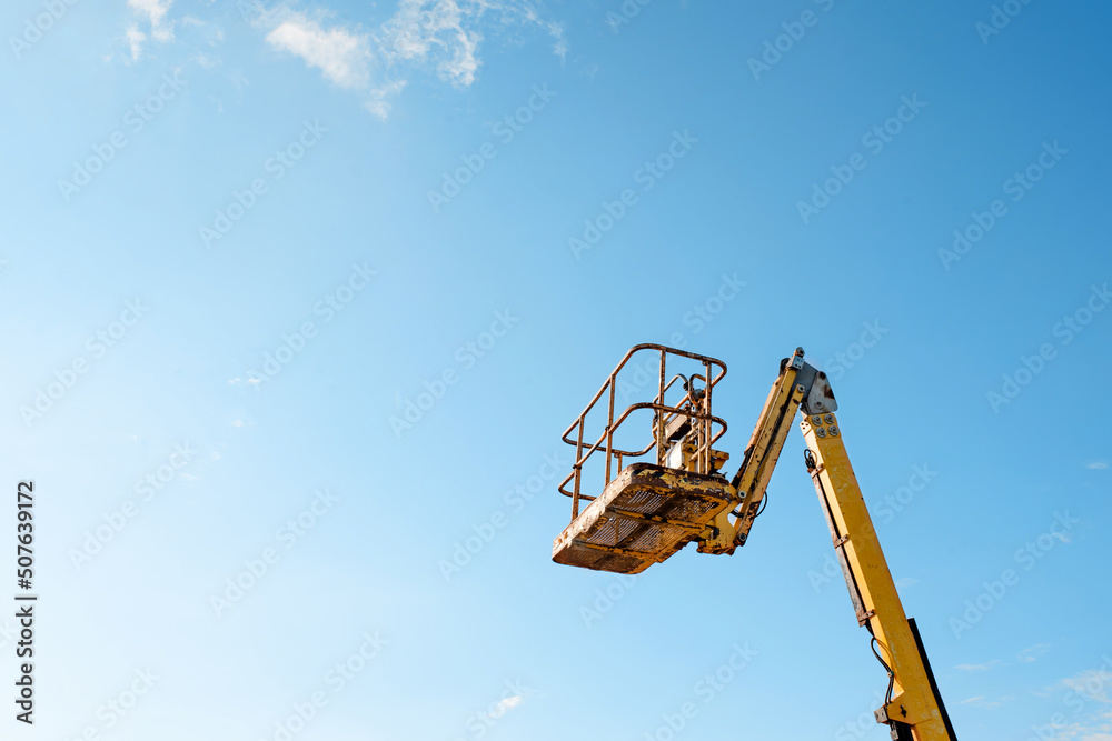 Telescopic boom lift rised up on blue sky background delivered to