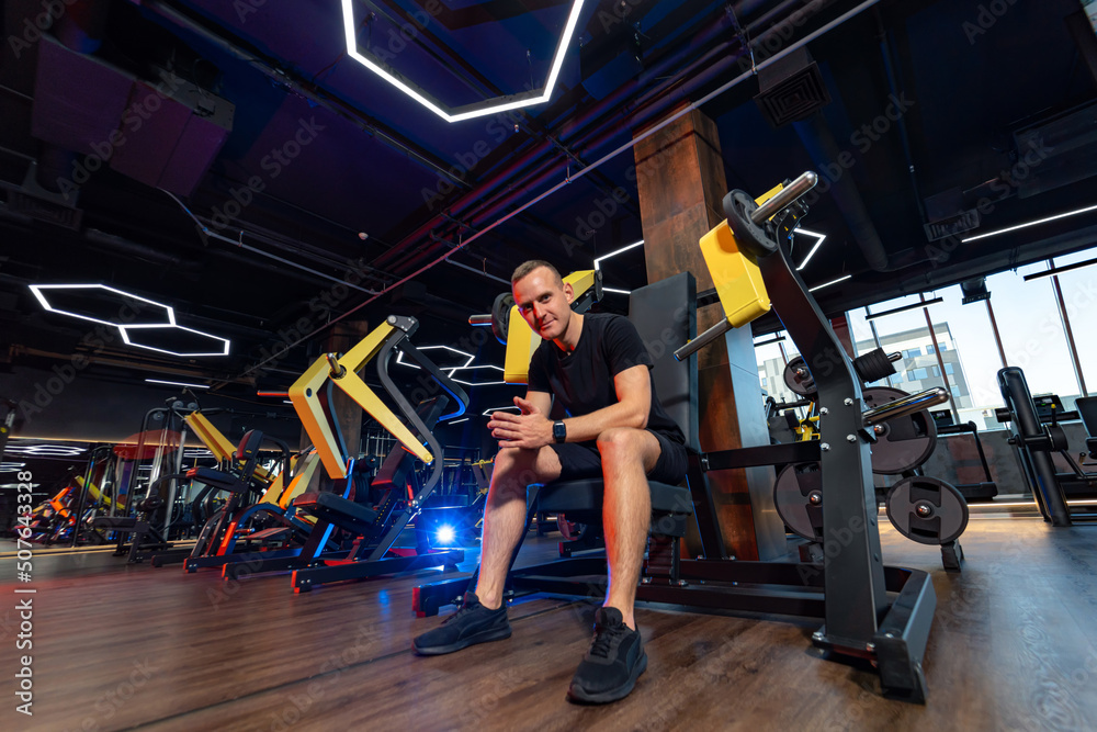 Strong man working out in modern gym. Young athletic bodybuilder training hard. Strong man working out in modern gym. Young athletic bodybuilder training hard.