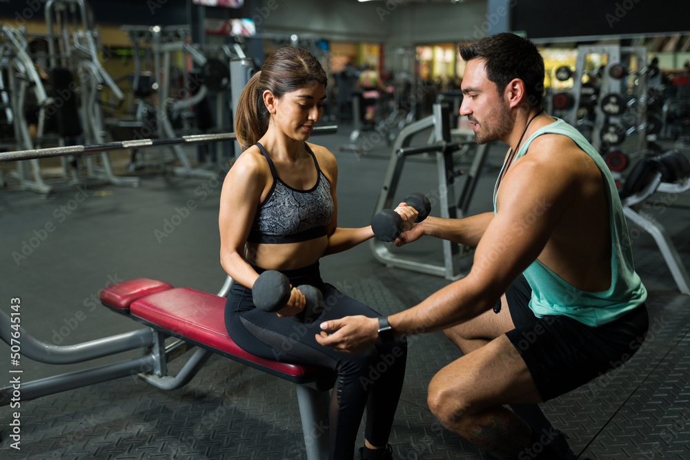 Hispanic sporty trainer teaching new exercises Hispanic sporty trainer teaching new exercises