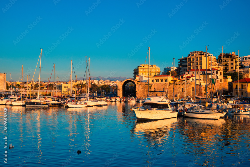 Venetian Fort castle in Heraklion and moored fishing boats, Crete Island, Greece on sunset