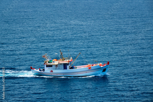 Greek fishing boat in blue waters of Aegean sea near Milos island, Greece