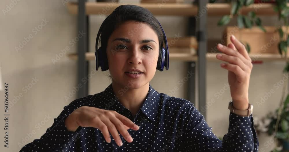 Head shot portrait Indian businesswoman sit indoor looking at camera talking lead negotiations use videocall app, blogger make speech, record videovlog for internet auditory. Video call event concept
