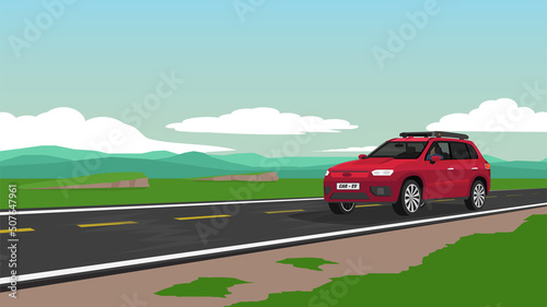 Red electric car for the family travel trip to nature. Driver came alone on the asphalt road. Road cuts across the vast plains with a complex mountainous background. Under blue sky and white clouds.