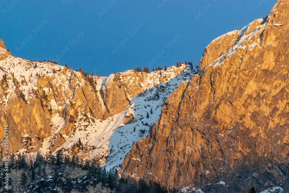 snow covered rocks in the dolomites during sunset