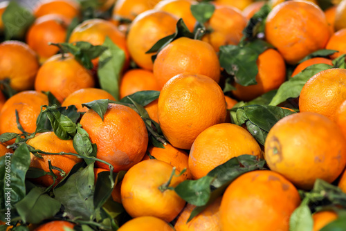 Fresh tangerine fruits with leaves as background, mandarin top view