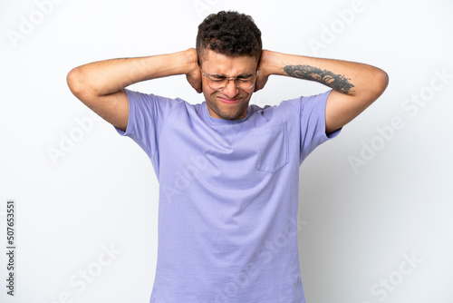 Young caucasian Brazilian man isolated on white background frustrated and covering ears © luismolinero
